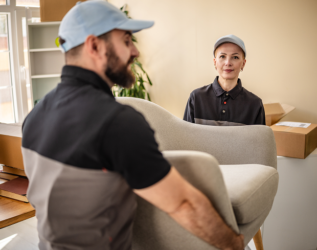 Two workers lifting furniture