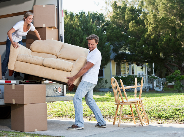 People moving furniture into a house