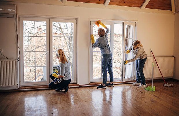 Three people cleaning glass doors